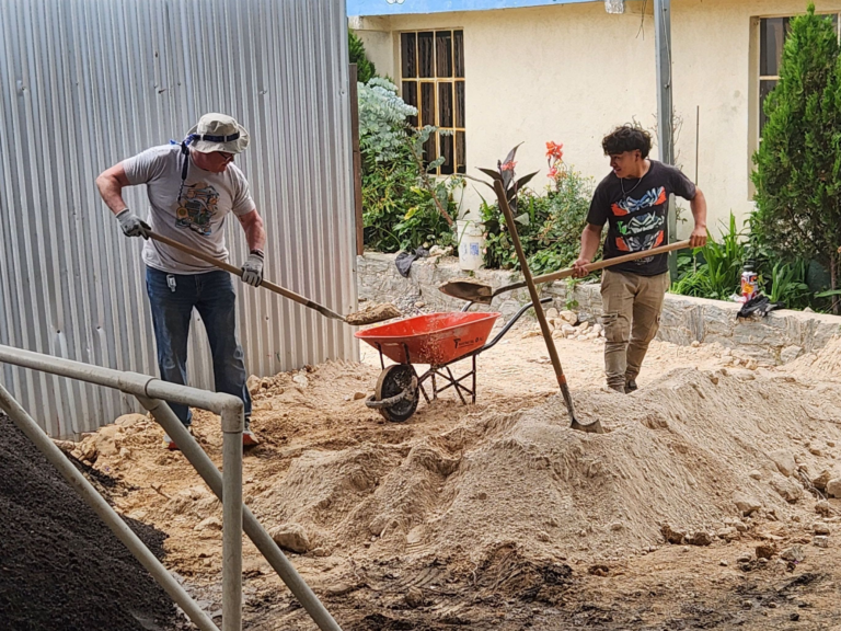 Violet Crown with local staff shoveling sand