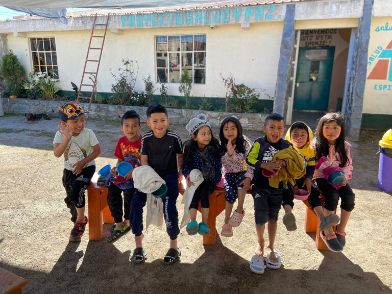 8 preschool students waving and smiling